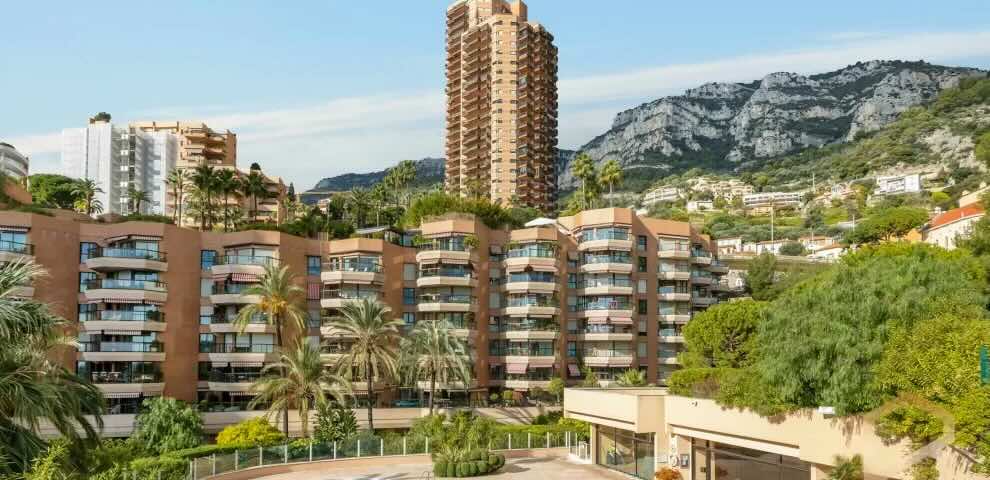 Monte Carlo Sun Monaco exterior, showcasing luxury high-rise architecture with lush tropical gardens.