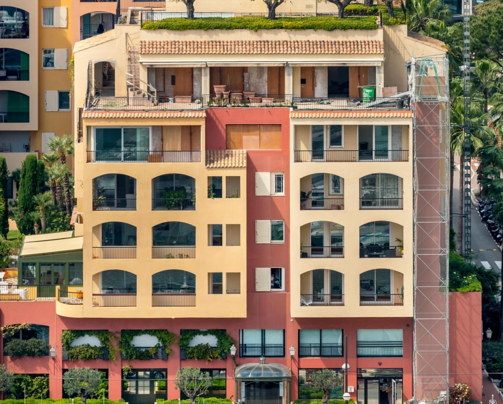 Colorful facade of Le Quattrocento, a luxury residence in Fontvieille, Monaco, with harbor views.