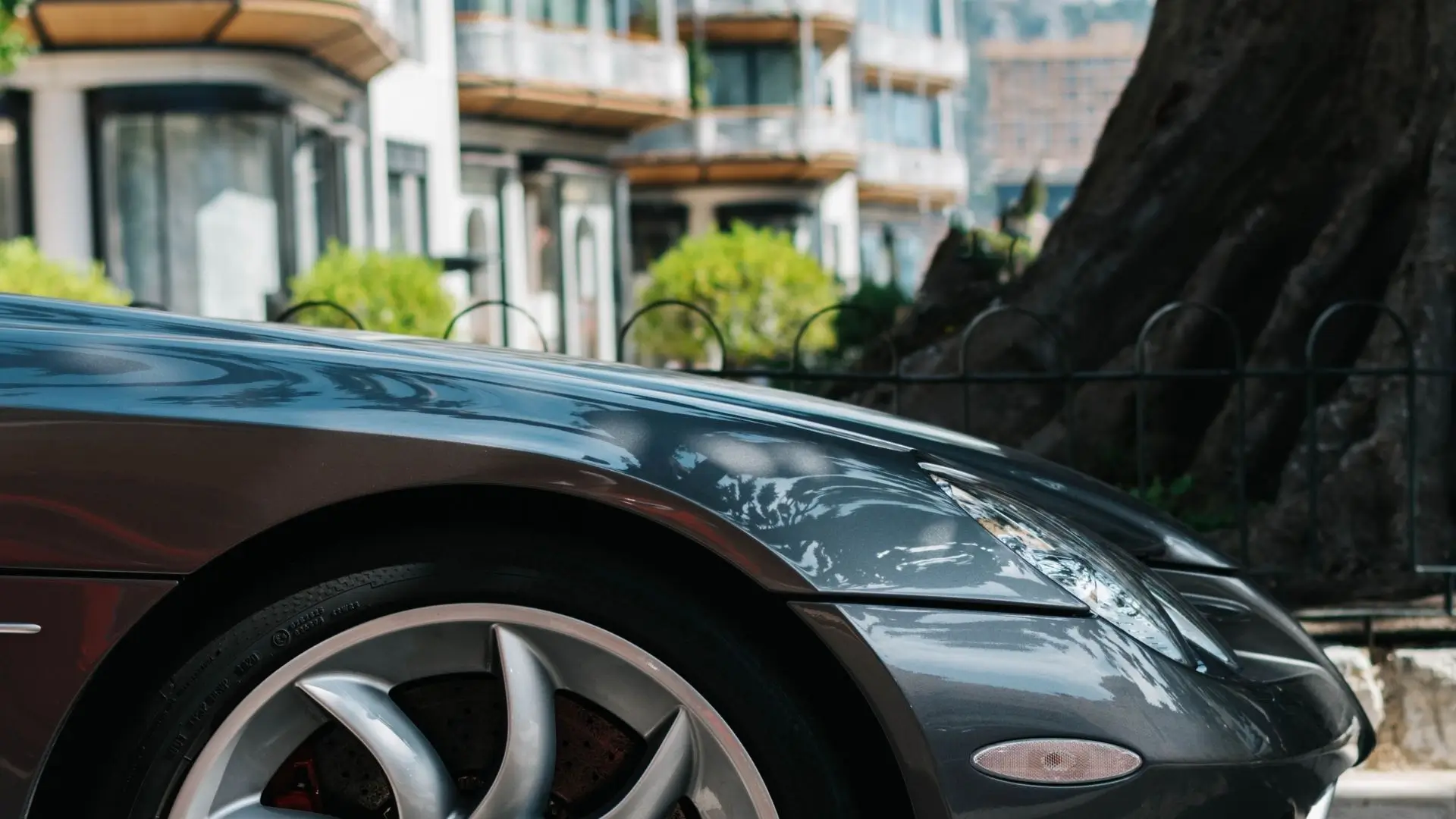 Luxury car parked in front of the Hôtel Hermitage, with Casino Square and the Carré d’Or district in the background.