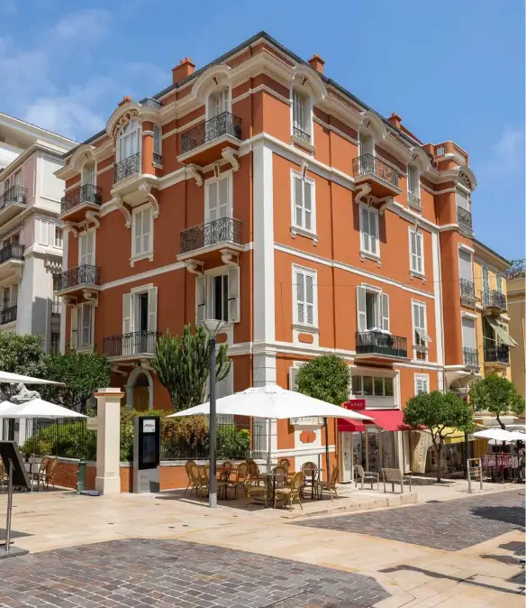 Bustling square in La Condamine with cafés, historic buildings, and local shops in Monaco.