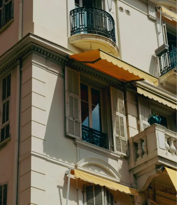 The exterior facade of a yellow residential building in Monaco