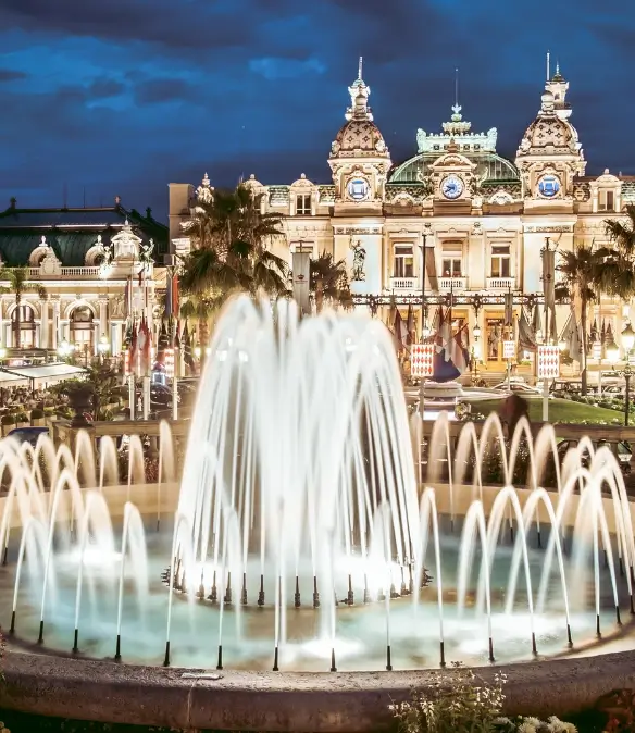 The Monte Carlo Casino photographed at night with a fountain in the foreground