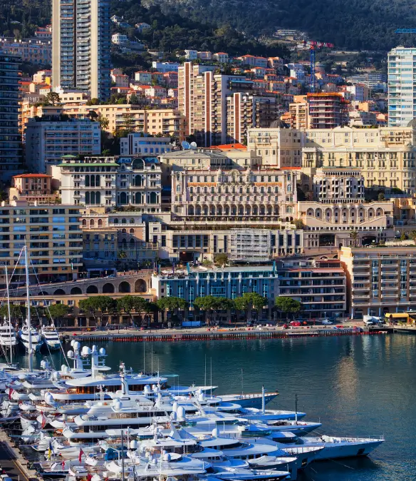 Port Hercule in Monaco, featuring superyachts docked in the port and luxury apartments surrounding the port